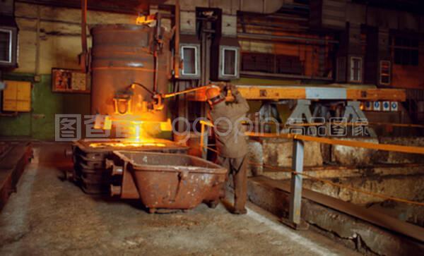 钢铁制造商从工厂的篮子里倒入液态金属